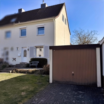 Frontansicht seitlich mit Garage - Celle-Neuenhäusen: Modernisierungsbedürftige DHH mit Keller und Garage auf sonnigem Grundstück